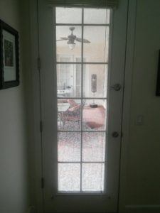 tempered glass patio door with grids and broken glass
